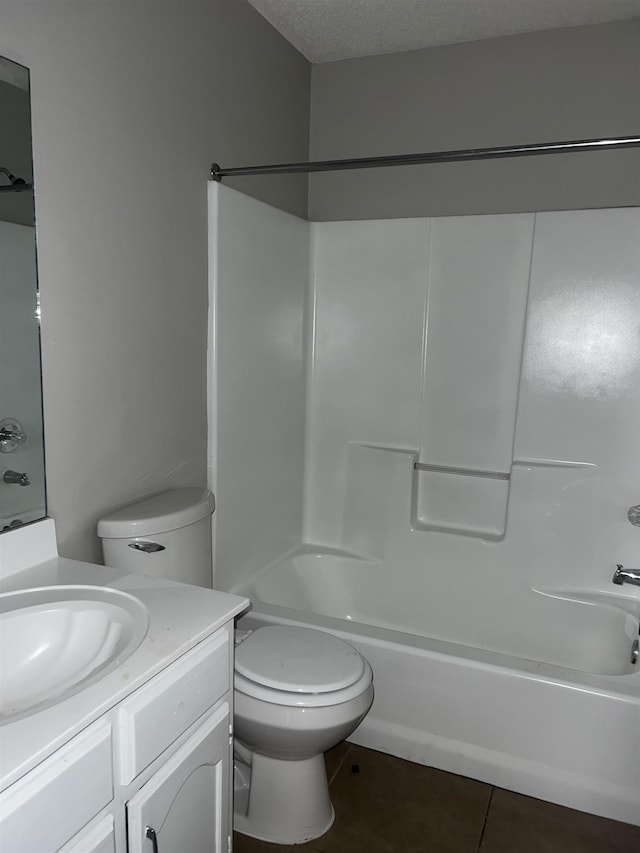 full bathroom with vanity, a textured ceiling, washtub / shower combination, tile patterned flooring, and toilet