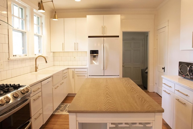 kitchen featuring a center island, white appliances, sink, tasteful backsplash, and white cabinetry