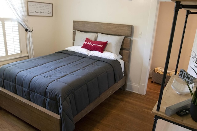 bedroom with dark hardwood / wood-style flooring