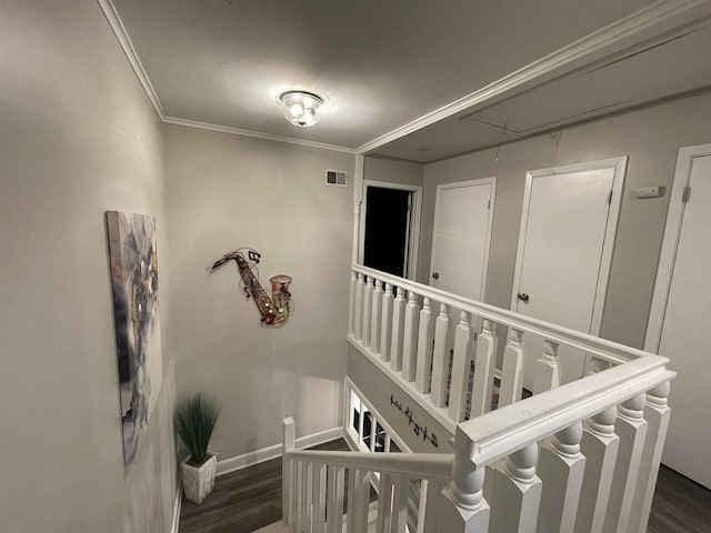 stairs with wood-type flooring and crown molding