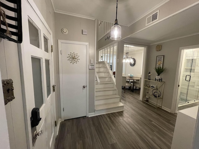 entrance foyer with a chandelier, dark wood-type flooring, and ornamental molding