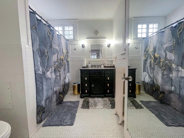 bathroom with walk in shower, vanity, tile walls, and ornamental molding