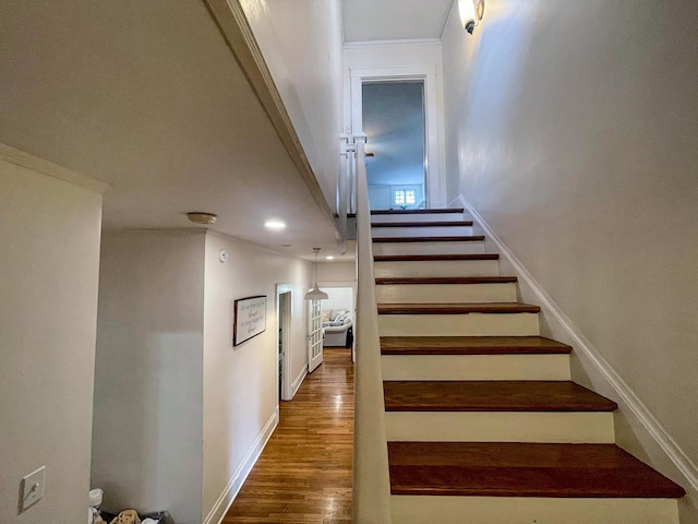 stairway featuring hardwood / wood-style flooring and crown molding