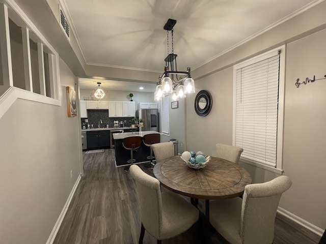 dining room with a notable chandelier, ornamental molding, sink, and dark wood-type flooring