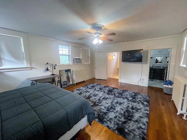 bedroom with ceiling fan, dark hardwood / wood-style floors, radiator heating unit, and connected bathroom