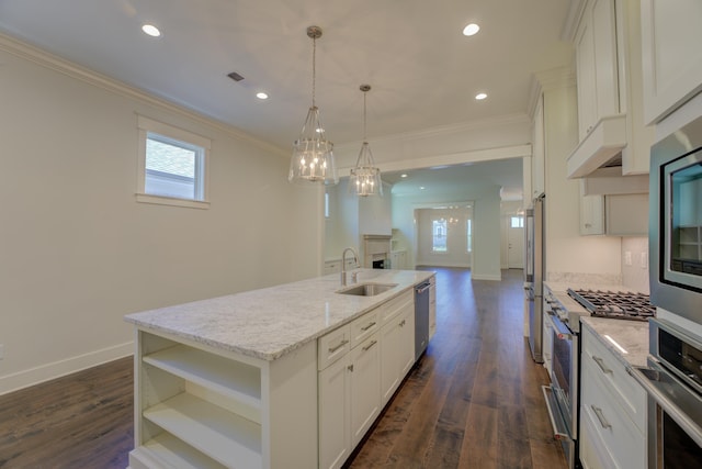 kitchen featuring white cabinets, a center island with sink, and hanging light fixtures