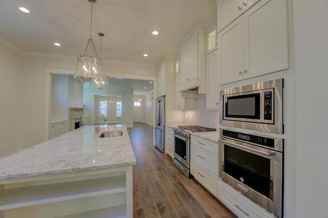 kitchen featuring a kitchen island with sink, sink, white cabinets, and appliances with stainless steel finishes