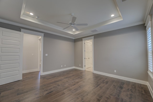 unfurnished room with a tray ceiling, crown molding, ceiling fan, and dark hardwood / wood-style floors