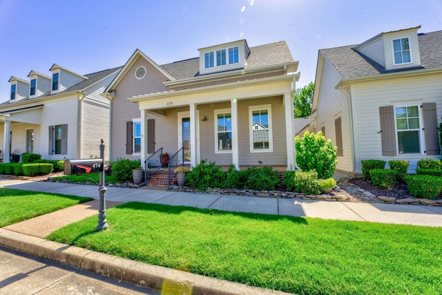 view of front of home with covered porch and a front lawn