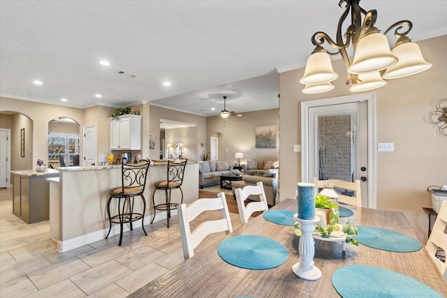 dining space featuring crown molding and a notable chandelier