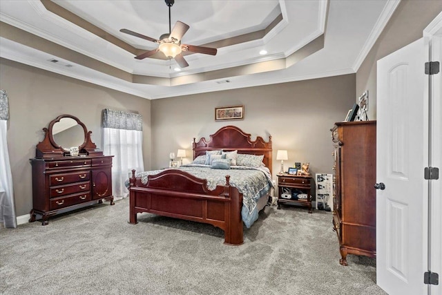 bedroom with a tray ceiling, crown molding, ceiling fan, and light colored carpet