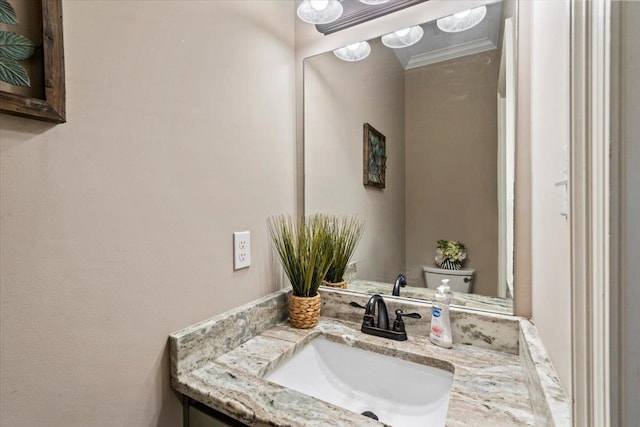 bathroom featuring vanity, toilet, and crown molding