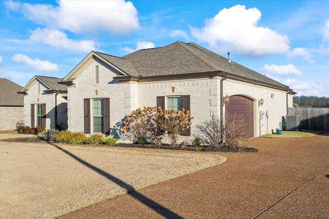 view of property exterior featuring central AC unit and a garage