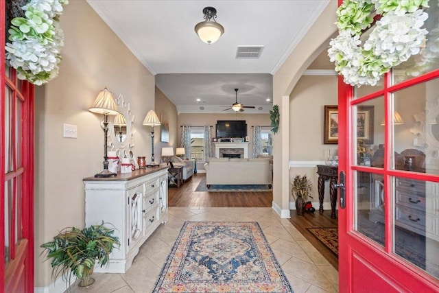 tiled foyer featuring ceiling fan and ornamental molding