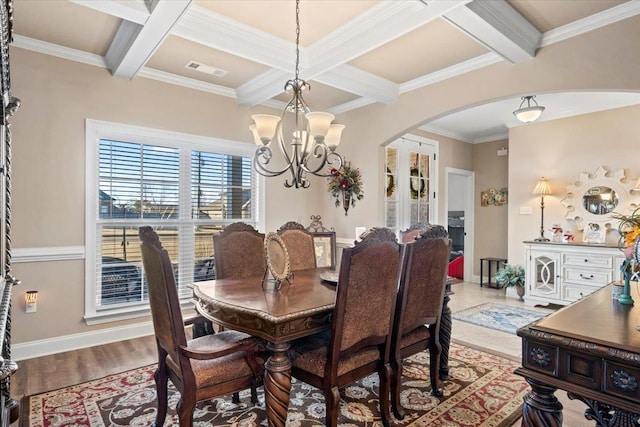 dining space featuring coffered ceiling, ornamental molding, beamed ceiling, a notable chandelier, and light hardwood / wood-style floors