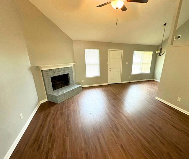 unfurnished living room with dark hardwood / wood-style flooring, a fireplace, ceiling fan with notable chandelier, and lofted ceiling