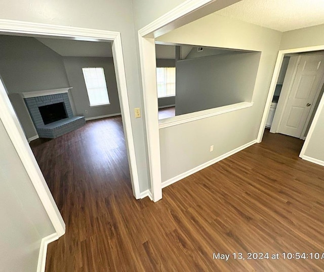 interior space featuring dark wood-type flooring and a brick fireplace