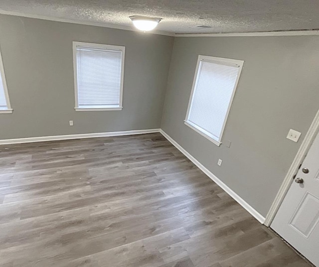 empty room with hardwood / wood-style floors and a textured ceiling