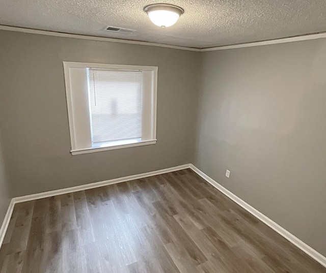 empty room featuring hardwood / wood-style flooring, crown molding, and a textured ceiling