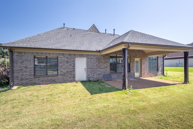 rear view of house featuring a lawn and a patio