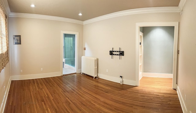 spare room with hardwood / wood-style flooring, radiator heating unit, and ornamental molding