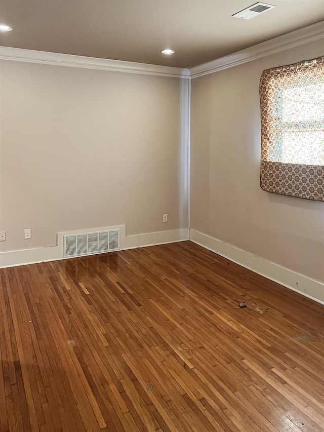 spare room featuring hardwood / wood-style floors and crown molding