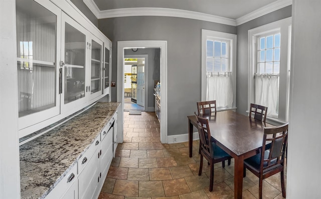 dining area with a wealth of natural light and crown molding