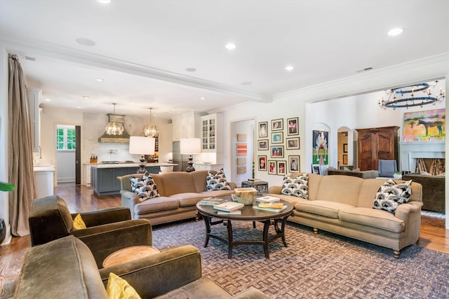 living room featuring a chandelier, hardwood / wood-style floors, and ornamental molding