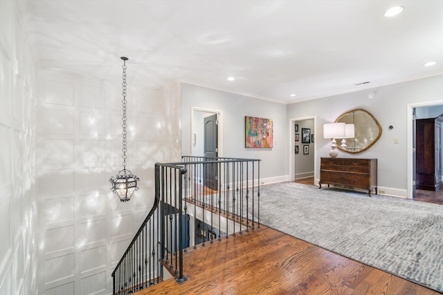 hall featuring wood-type flooring and crown molding