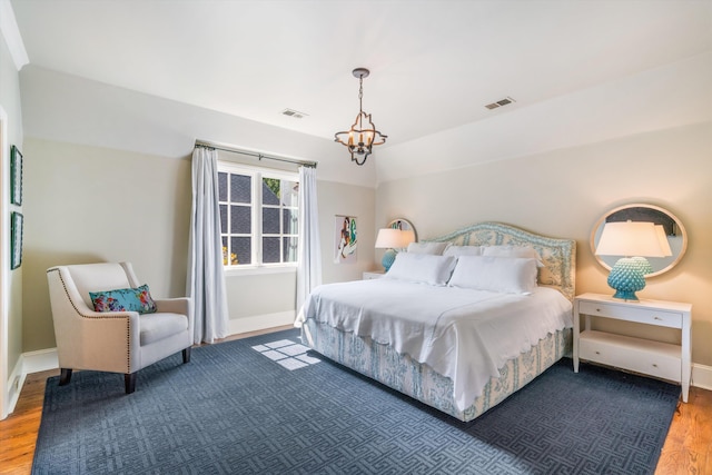 bedroom featuring lofted ceiling, dark hardwood / wood-style floors, and a notable chandelier