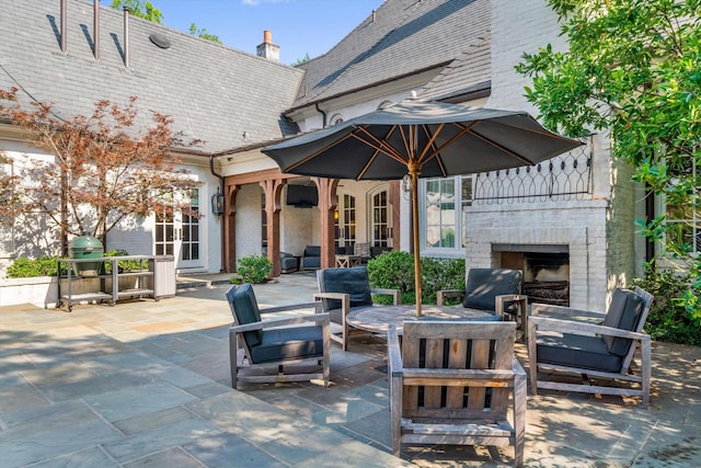 view of patio / terrace with french doors and an outdoor brick fireplace