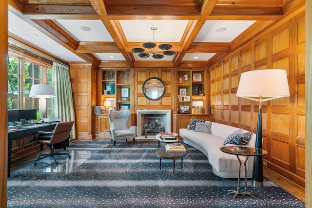 carpeted office featuring built in shelves, coffered ceiling, beamed ceiling, wooden walls, and built in desk