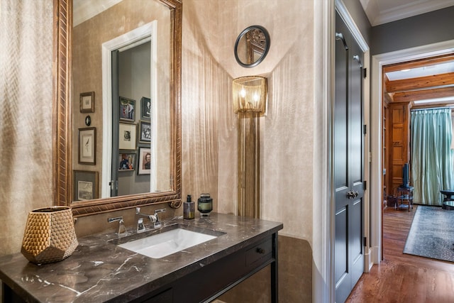 bathroom with crown molding, vanity, and wood-type flooring