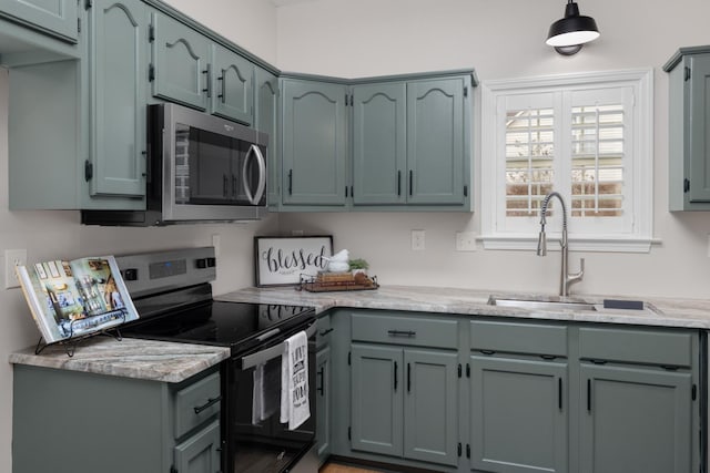 kitchen featuring light stone countertops, appliances with stainless steel finishes, and sink