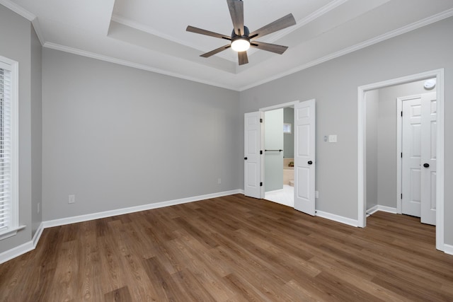 unfurnished bedroom with wood-type flooring, a raised ceiling, ceiling fan, and crown molding