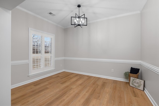 unfurnished dining area with crown molding, hardwood / wood-style floors, and a chandelier