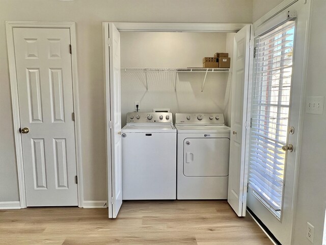 laundry room featuring washing machine and dryer and light wood-type flooring