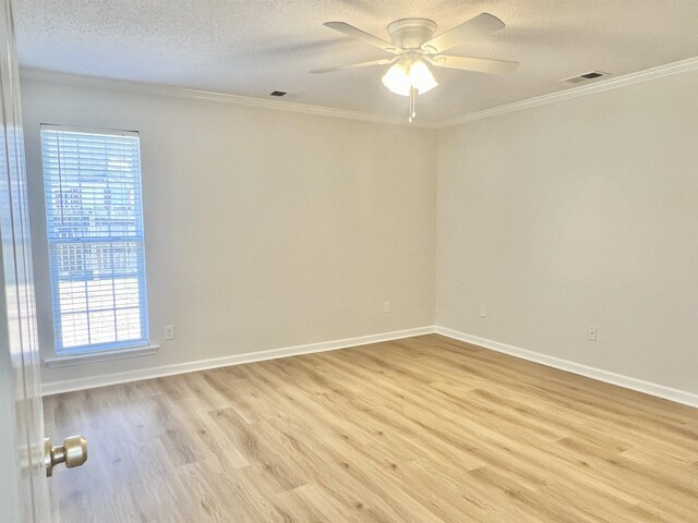 spare room featuring light hardwood / wood-style floors, a wealth of natural light, ornamental molding, and ceiling fan