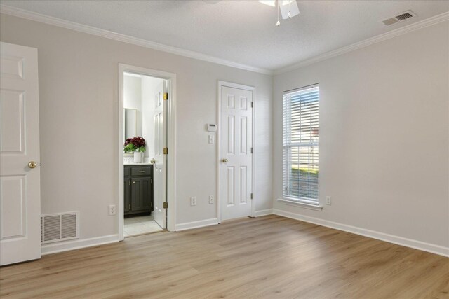 unfurnished room featuring light hardwood / wood-style floors, ceiling fan, and crown molding