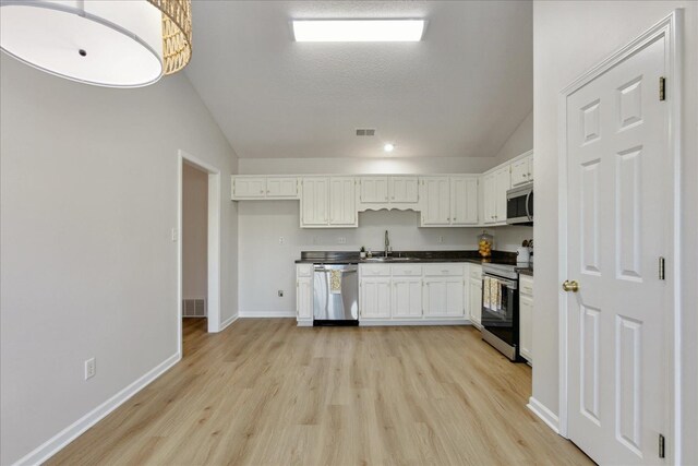 kitchen featuring sink, white cabinets, light hardwood / wood-style floors, and appliances with stainless steel finishes