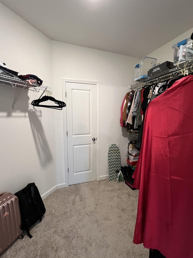 walk in closet with light carpet and radiator heating unit