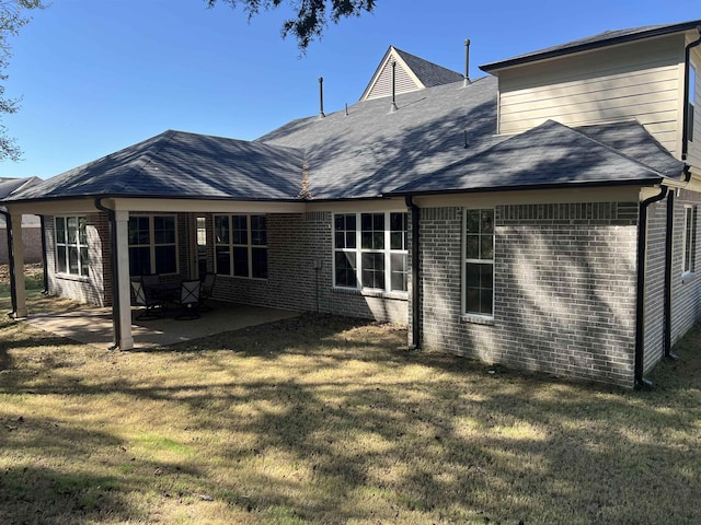 back of property featuring a patio area and a yard