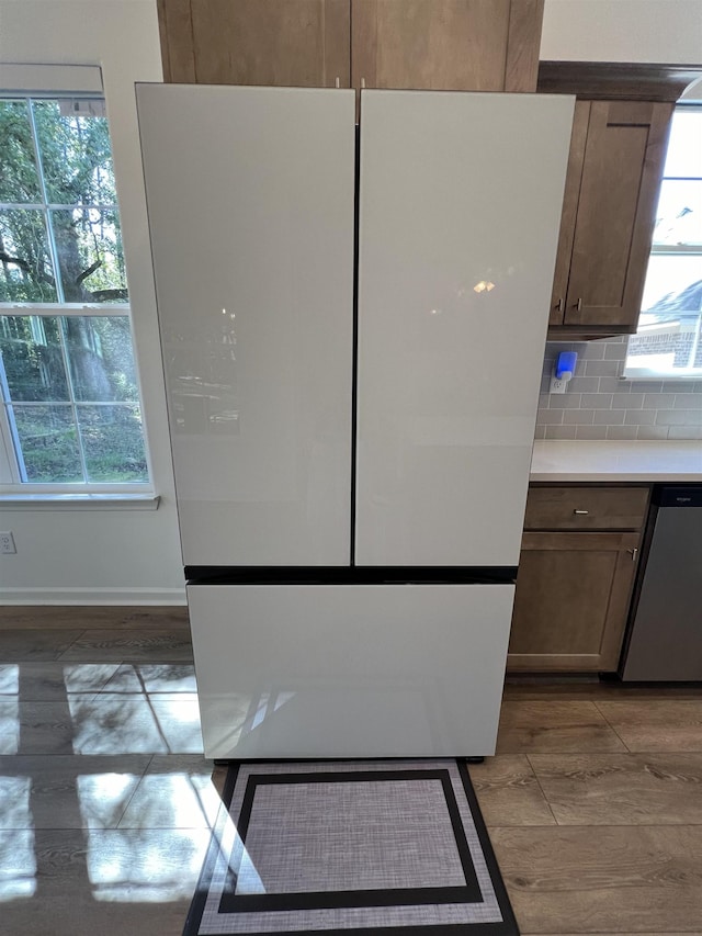 kitchen featuring tasteful backsplash, stainless steel dishwasher, and white refrigerator