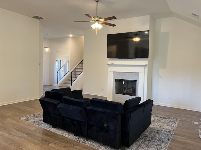 living room featuring ceiling fan, a fireplace, vaulted ceiling, and hardwood / wood-style flooring