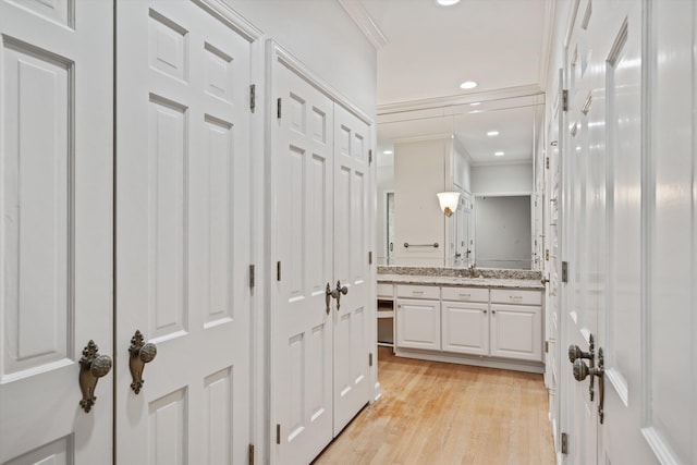 bathroom featuring hardwood / wood-style floors, vanity, and crown molding