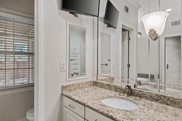 bathroom featuring walk in shower, vanity, ornamental molding, and toilet