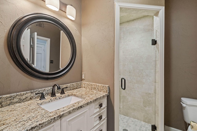 bathroom with vanity, toilet, and a shower with shower door