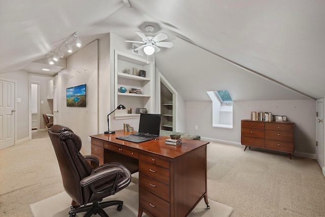 office space featuring built in shelves, ceiling fan, light carpet, and vaulted ceiling