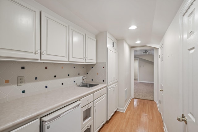 kitchen featuring white cabinets, sink, white dishwasher, and light hardwood / wood-style floors