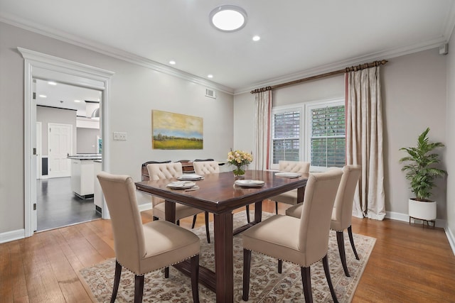 dining room with dark wood-type flooring and ornamental molding